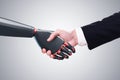 Man shaking robot hand, concrete wall Royalty Free Stock Photo