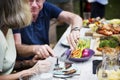 Man sharing food to woman at backyard barbecue party Royalty Free Stock Photo