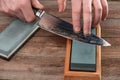 Man sharpening a chef`s knife with Damascus steel