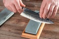 Man sharpening a chef`s knife with a wet stone