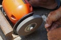 A man is sharpening iron using an orange-colored grinding machine Royalty Free Stock Photo