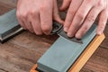 Man sharpening a pocket knife using a whetstone Royalty Free Stock Photo