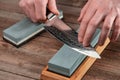 Man sharpens a Gyuto knife using a whetstone Royalty Free Stock Photo