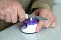 Man sharpens a kitchen knife with a sharpener on the table Royalty Free Stock Photo