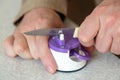Man sharpens a kitchen knife with sharpener on the table Royalty Free Stock Photo