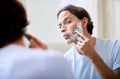 Man shave face in mirror, foam and beauty with morning routine, cosmetic care and grooming at home. Male person in Royalty Free Stock Photo