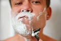 A man shaves his face with a safety razor. Royalty Free Stock Photo