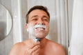 A man shaves his face with a safety razor. Royalty Free Stock Photo