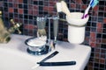 Man shaving accessories safety razor, straight razor, cup with foam and brushes on the sink, mosaic tile background. Royalty Free Stock Photo