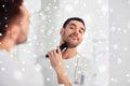 Man shaving beard with trimmer at bathroom Royalty Free Stock Photo