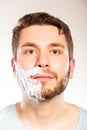 Man with shaving cream foam on half of face. Royalty Free Stock Photo