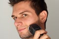 Man shaving face with electric razor