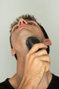 Man shaving face with electric razor Royalty Free Stock Photo