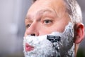 Man shaving himself with a razor Royalty Free Stock Photo