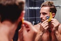 Man shaving his beard in the bathroom Royalty Free Stock Photo