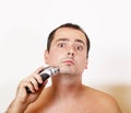 Man shaving his beard with an electric razor Royalty Free Stock Photo