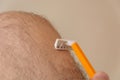Grooming Mastery: Man\'s Hand Expertly Shaving Hairy Legs at Home