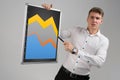 Young man holding a magnetic Board with a graph isolated on a light background