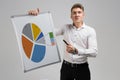 Young man holding a poster with a diagram isolated on a light background