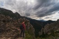 A man in a shirt with a briefcase behind his back is hiking in the Tatra mountains on a summer evening, the sky with thick clouds Royalty Free Stock Photo