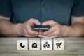 Man in a shirt holding a phone, wooden blocks with symbols, email, telephone, shopping cart, Creative concept for convenient