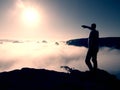 Man in shirt and jeans is standing on the peak of sandstone empire and watching over the misty and foggy morning valley. Beautifu Royalty Free Stock Photo