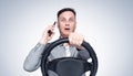 Man in shirt and tie talking on the phone while driving, front view on light background. Royalty Free Stock Photo