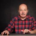 Man in shirt works at the computer, typing text on keybo Royalty Free Stock Photo