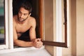Man, shirtless or window to relax, thinking or memory of break, idea or vision of dream summer home. Guy, tourist or Royalty Free Stock Photo
