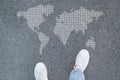 Man in shoes standing in asphalt and world map