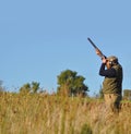 A man shooting Ducks with blue sky background for text copy