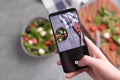 Man shooting fresh vegetable salad with mozzarella and spinach on cell phone camera. Cooking, blogging and healthy Royalty Free Stock Photo