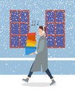 Man with shopping boxes walks on the street in winter. Guy with headphones is listening to music Royalty Free Stock Photo