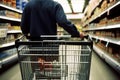Man with shopping cart in supermarket. Shallow depth of field. Closeup rear view of a man strolling a shopping cart, AI Generated