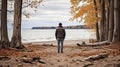 A man on the shore of a lake or the sea looks longingly into the distance