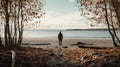 A man on the shore of a lake or the sea looks longingly into the distance