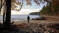 A man on the shore of a lake or the sea looks longingly into the distance