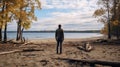 A man on the shore of a lake or the sea looks longingly into the distance