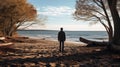 A man on the shore of a lake or the sea looks longingly into the distance