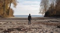 A man on the shore of a lake or the sea looks longingly into the distance