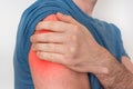 Man with shoulder pain is holding his aching arm