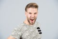 Man shout angry in tshirt on grey background Royalty Free Stock Photo