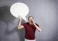 Man shouting with empty speech ballon in hand. Royalty Free Stock Photo