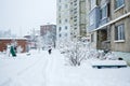 A man with a shovel cleaning and clearing snow in front of the house on a frosty day. Cleaning the street from snow on a winter Royalty Free Stock Photo