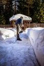 Man with shovel removing snow from sidewalk after snowstorm. Winter time in outdoors, clearing snow from backyard Royalty Free Stock Photo