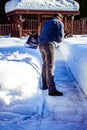 Man with shovel removing snow from sidewalk after snowstorm. Winter time in outdoors, clearing snow from backyard Royalty Free Stock Photo