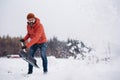 Man shoveling snow with shovel, cleaning driveway in front of the house. Scooping and throwing snow, shoveling. Royalty Free Stock Photo