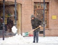 Man shoveling winter snow in the city street