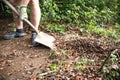 Man shovelling garden waste leaves with a shovel