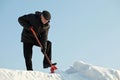 Man shovelling snow with a red shovel